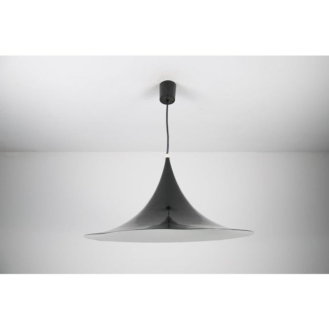This fog & mørup designer ceiling lamp is an elegant piece crafted from thin aluminum with a black coating, shaped like a...