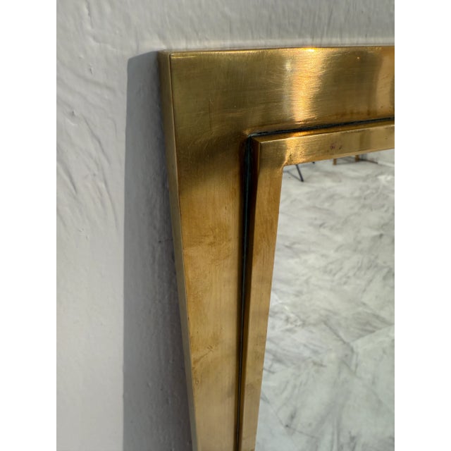 Elegant mid-century rectangular mirror framed in solid brass, exuding timeless Italian craftsmanship. The sleek,...