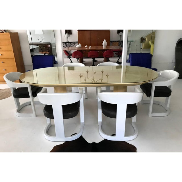 A set of four "Jackie Onassis" chairs by Karl Springer, circa 1980s. Finished in glossy white lacquer and upholstered in a...