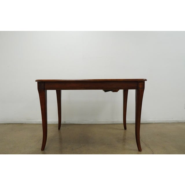 This vintage dining table showcases a timeless traditional design with elegant Queen Anne–style cabriole legs and a warm...