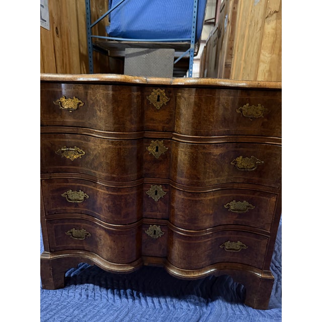 The craftsmanship is a masterclass in early European veneer work. The top surface, drawer fronts, and side panels are...