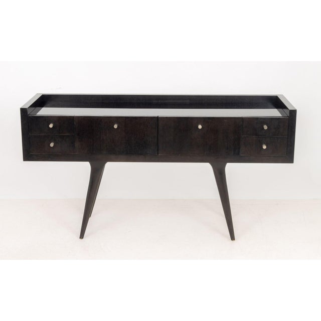 Troy Wesnidge Inc. Modern Ebonized Wood Sideboard, with black glass top above two central drawers flanked by two rows of...