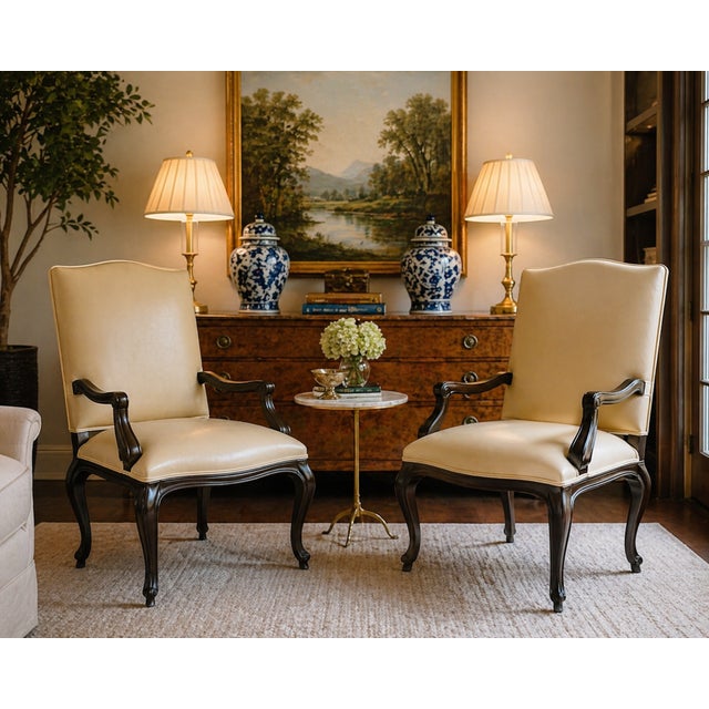 A refined pair of cream leather armchairs by Kreiss, showcasing an elegant interpretation of classic English Chippendale...