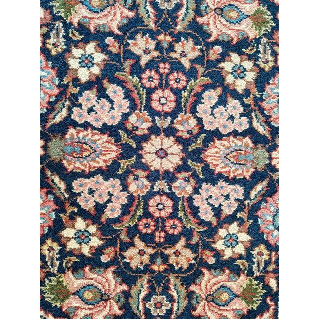 This elegant hand-knotted runner rug was woven during the mid-20th century and features a refined all-over floral design...