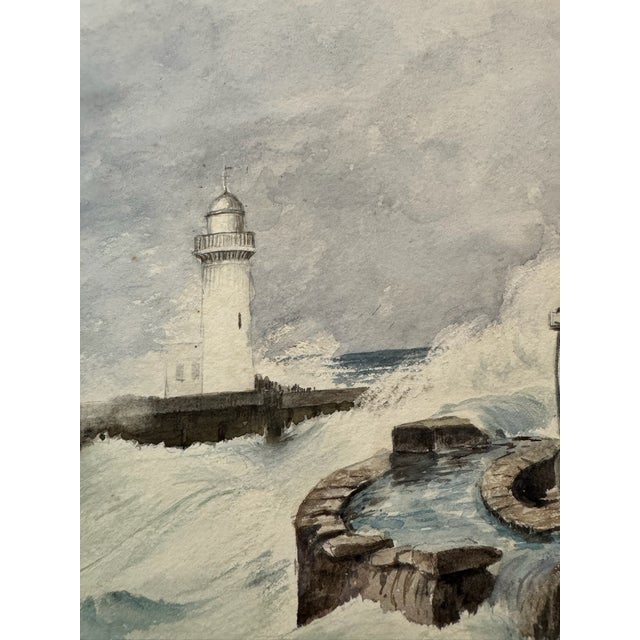 Dramatic original watercolor on paper depicting a lighthouse and harbor battered by large breaking waves, with a small...