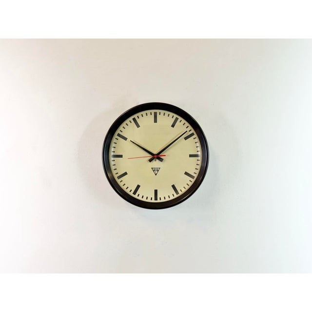 This wall clock was produced by Pragotron in former Czechoslovakia during the 1960s. It features a brown bakelite frame,...