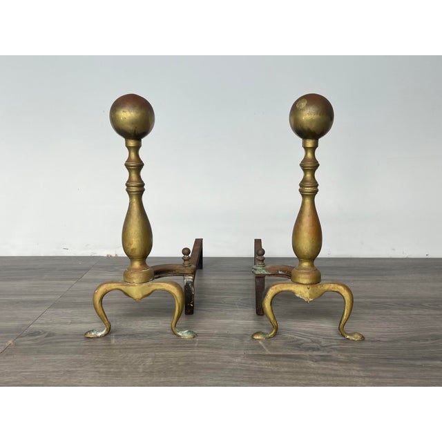 Pair of cannonball brass fireplace andirons Theses andirons have some wear and patina Dimensions: 7”Width x 17.5”Depth x...