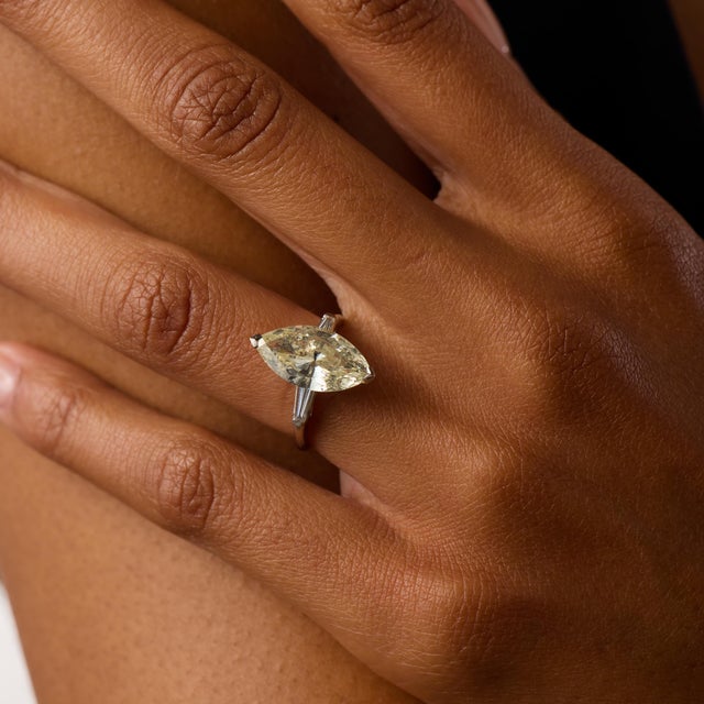 This striking Mid Century engagement ring centers on an impressive 3.83 carat marquise cut diamond, certified by GIA...