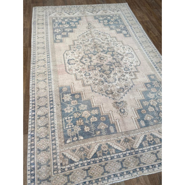 A charming vintage Oushak rug with blue and beige tones.
