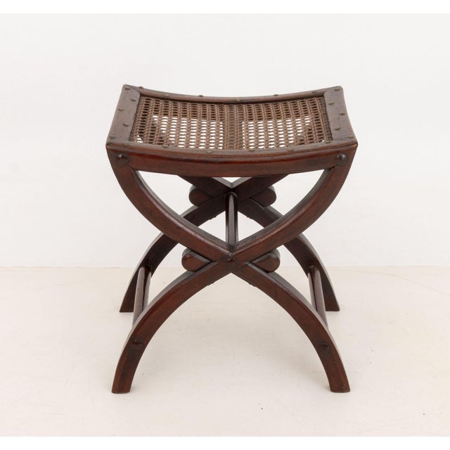 Arts and Crafts Cane-Paneled Mahogany Curule Bench, with brass nailhead details. 19.75" H x 18.25" W x 16.25" D....
