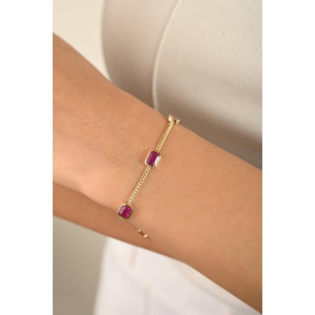 Delicate yet radiant, this 14K yellow gold ruby station bracelet features three vivid octagon-cut natural rubies bezel-set...