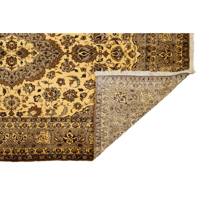 This vintage handmade Tabriz rug features a striking yellow field adorned with a medallion design and vibrant multicolor...