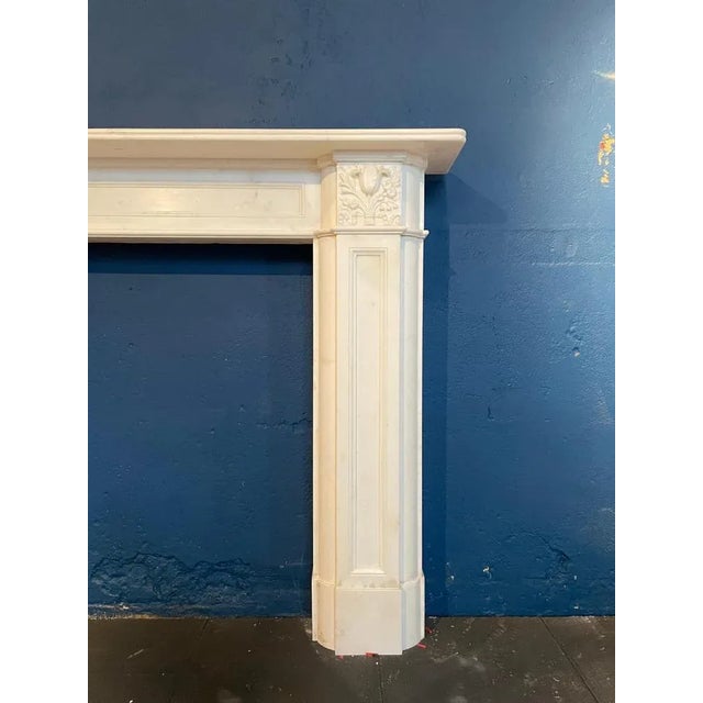 A large and well proportioned Regency fireplace in Statuary white marble. The panelled jambs with cushioned side returns...