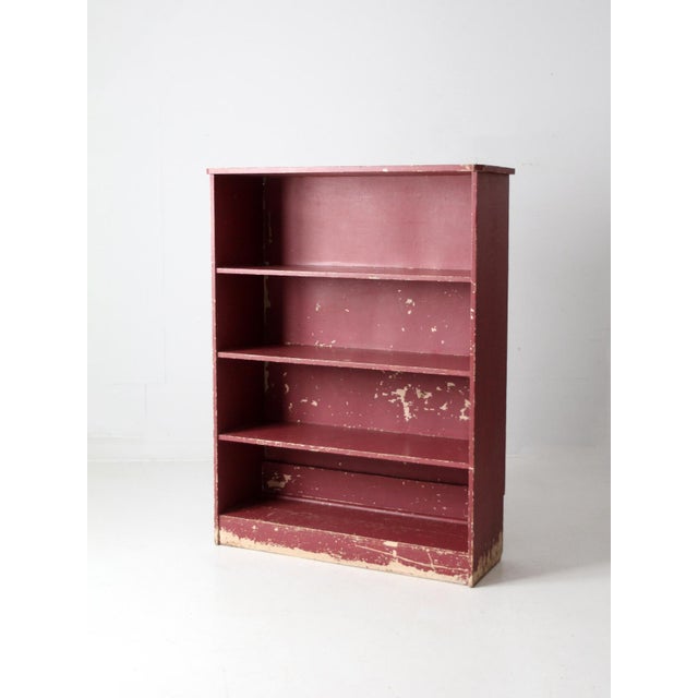 This antique painted primitive bookcase shelf features four shelves and beautifully aged rose red paint. It is a charming...