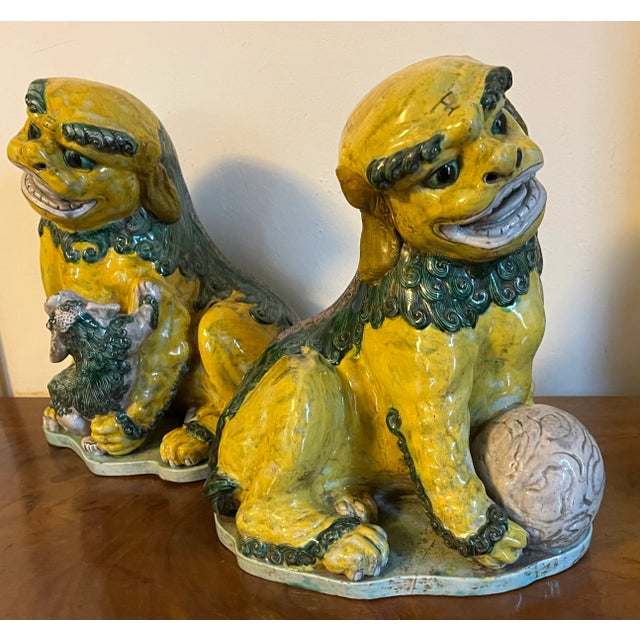 Pair antique 18th century Chinese famille vert pottery foo lion dogs. One with a ball in its paw, the other with pup....