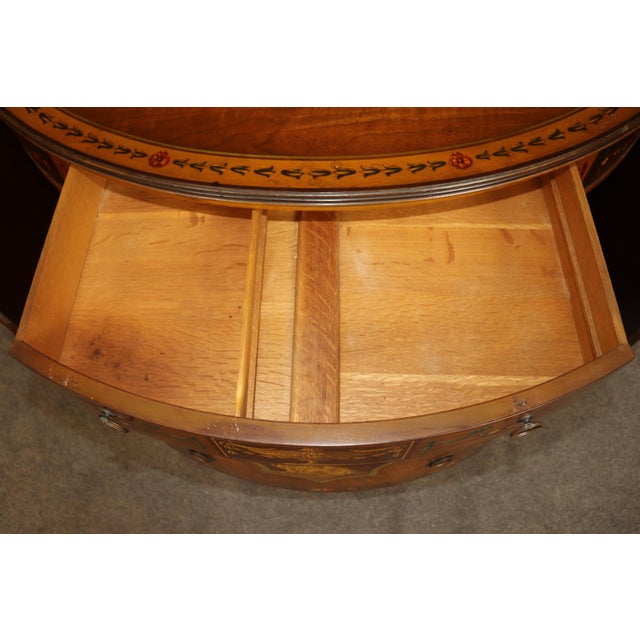 An exceptionally decorative American-made walnut commode in the Adam style, distinguished by its elegant bowed form and an...