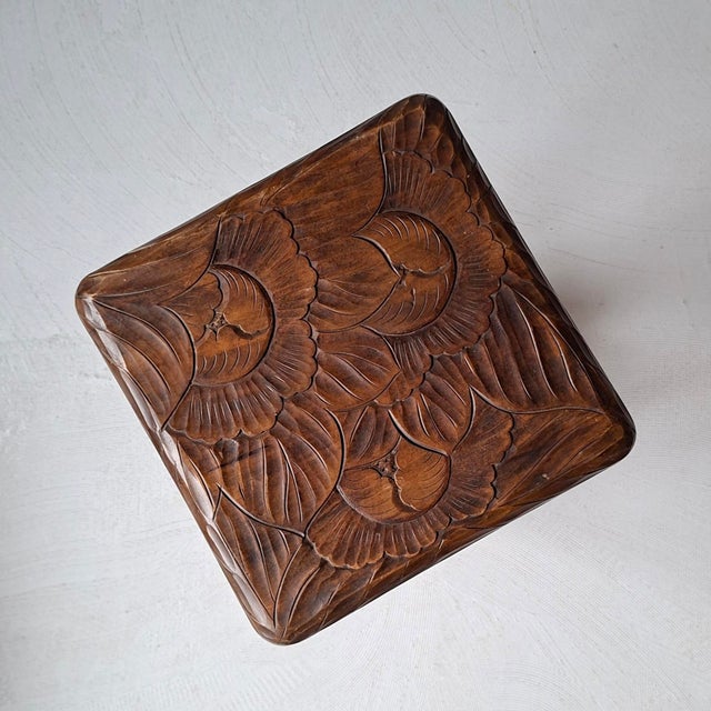 Both top and under tier of this small side table are covered with high relief carvings of flowers. Hand-carved in Japan....