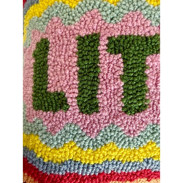 Here is a colorful “Lit AF” decorative pillow by Furbish Studio, featuring a playful hand-hooked design in a vibrant mix...