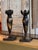 Pair of black tole candlesticks with gilt decoration, raised on square bases. Decorated throughout with chinoiserie-style...