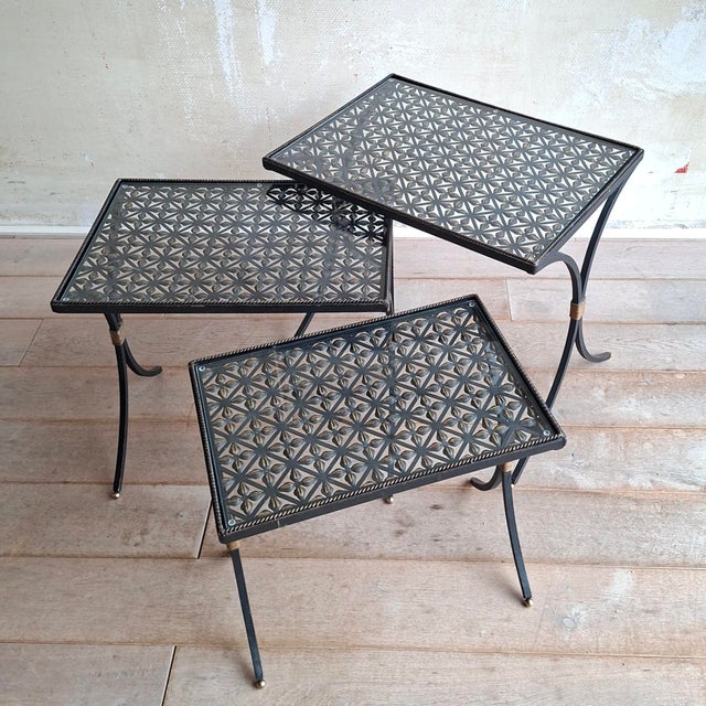 This set of side tables (nesting tables) is made of wrought iron, black with gold-colored accents. Equipped with glass...
