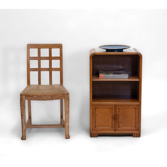 A silky oak side cabinet designed by betty joel and made by w v irwin at token works. Dated 1931. the label bears betty...