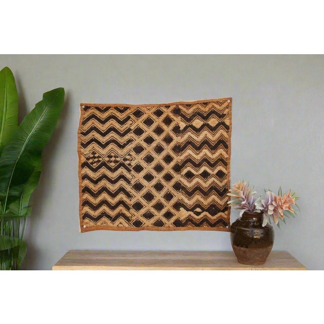 A captivating masterpiece of African textile art, this vintage Kuba cloth panel is a testament to the unparalleled...