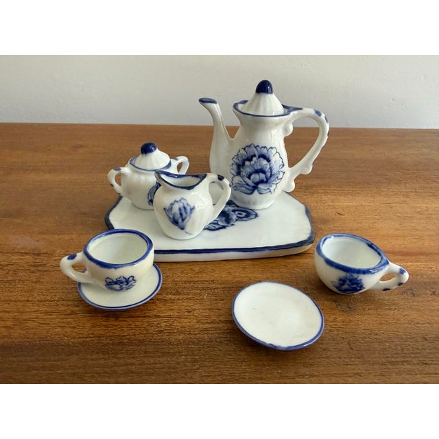 1970s miniature porcelain tea set. The blue and white tea service features hand painted flowers and includes a tea pot...