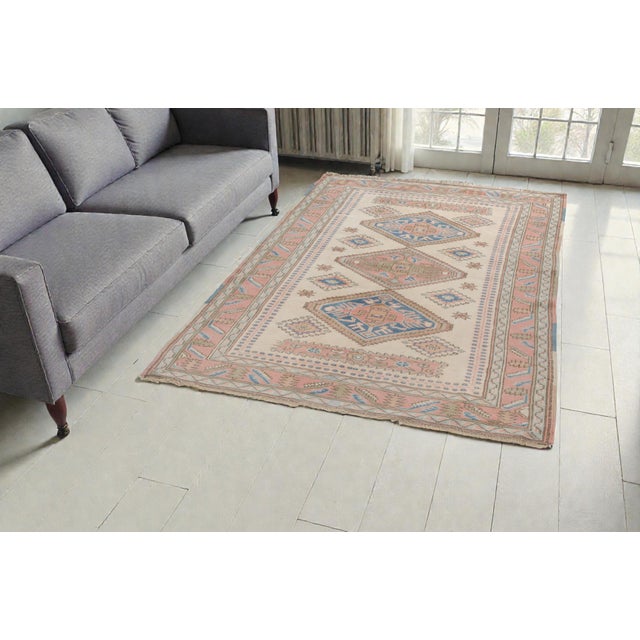 This is a vintage Turkish Oushak rug from the Mid 20th Century. The piece was hand-knotted.