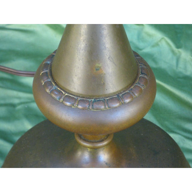 This Tabe Lamp is a vintage piece from the 1930s, featuring a geometric Art Deco design made of antique brass. Standing at...