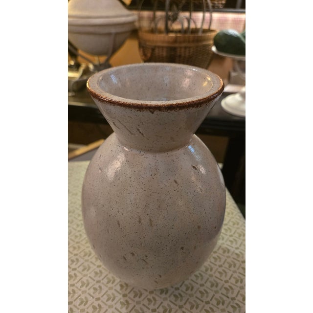 Heavy-weighted beige pottery with a brown accented flared rim. Unique finish with specs of brown and lashes or cuts...