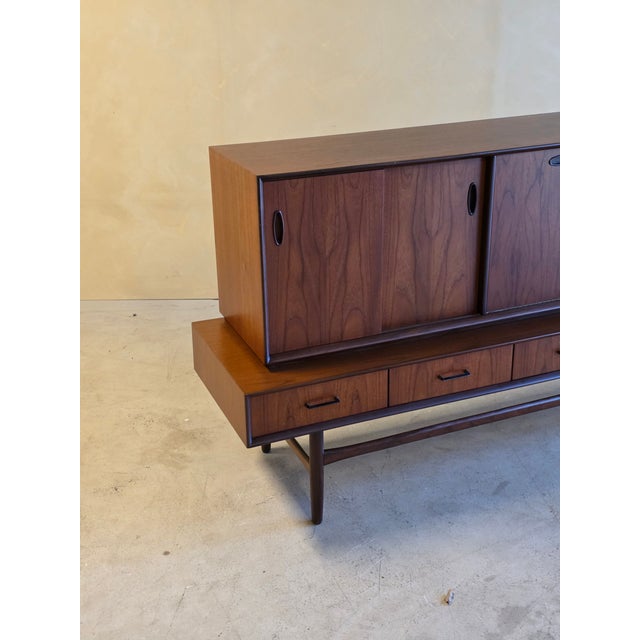Amazing teak sideboard that comes in 2 pieces. In refinished condition. 5 opening drawers and 5 opening doors. Door handle...