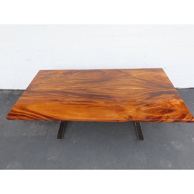 This striking dining table is crafted from solid mahogany and metal, featuring a contemporary modern design with a long,...
