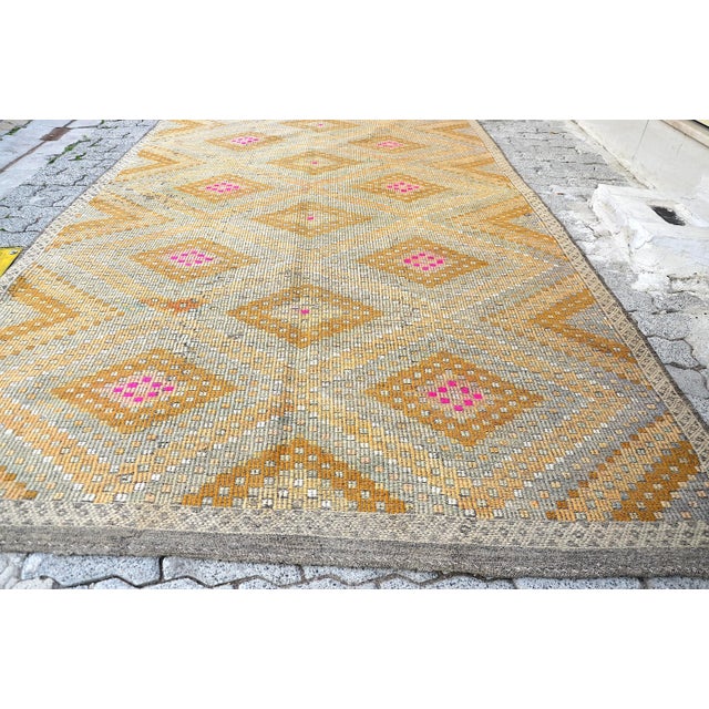 This is a vintage Turkish Anatolian kilim rug from the 1960s. The piece was hand-woven.