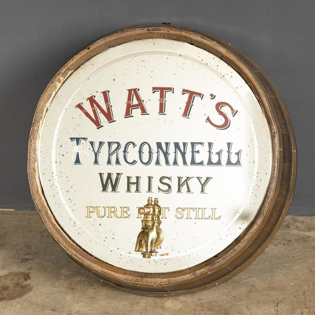 Antique 20th Century rare advertising mirror. This Watts Irish Whisky mirror has been framed in a slice of an oak barrel...