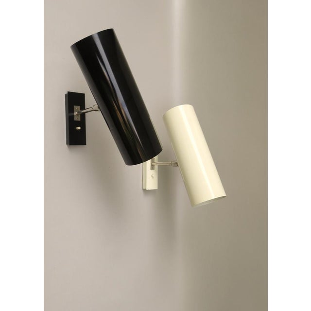 A pair of minimalist wall lights from the 60s of bünte & remmler in the noble combination of light beige and black. the...