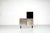 The "Parioli System" sideboard is a tall cabinet made of black-stained ash, accented with satin-finish stainless steel...