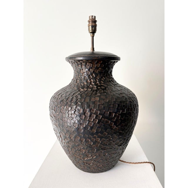 A large handmade table lamp in terracotta with a rich brown glaze, dating from the late 20th century. The impressed...
