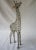 Charming modernist metal sculpture/figurine of a giraffe. It measures 12"H x 4"W x 1.5"D and is in excellent condition.