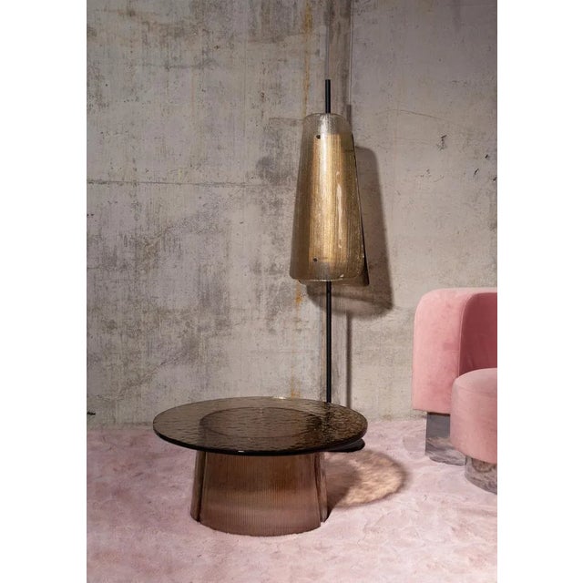 The conical glass sections of Sebastian Herkner's floor lamps bent are a bow to the classic lampshade. The fluted glass is...