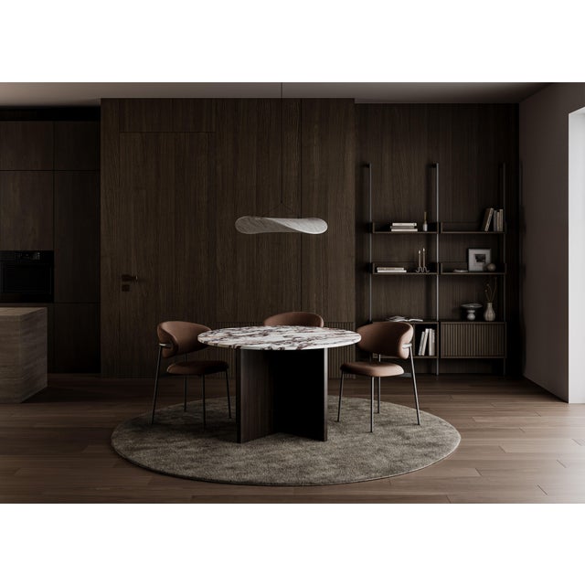 Two materials, one line. The Hakata is a table scaled for a room and its company, its marble surface carried on a base of...