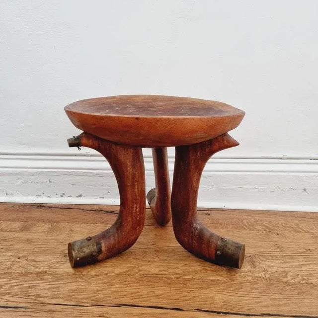 Three legged tribal stool from Southern Ethiopia. Light reddish wood the legs are partly covered with brass. Early 1900s /...