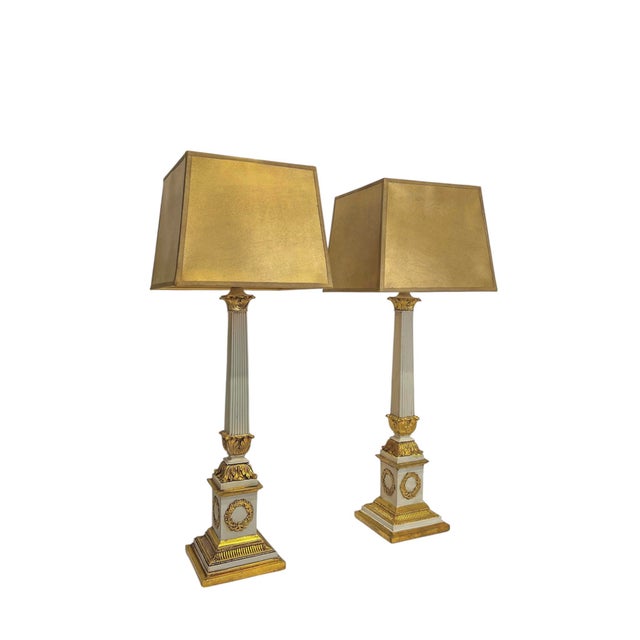 A pair of impressive neoclassical table lamps, painted in white and gold, in the louis xvi style. the lamp bases feature...