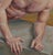 In "Blake of Night," a muscular figure reclines against a stark landscape, exuding a sense of vulnerability and strength....