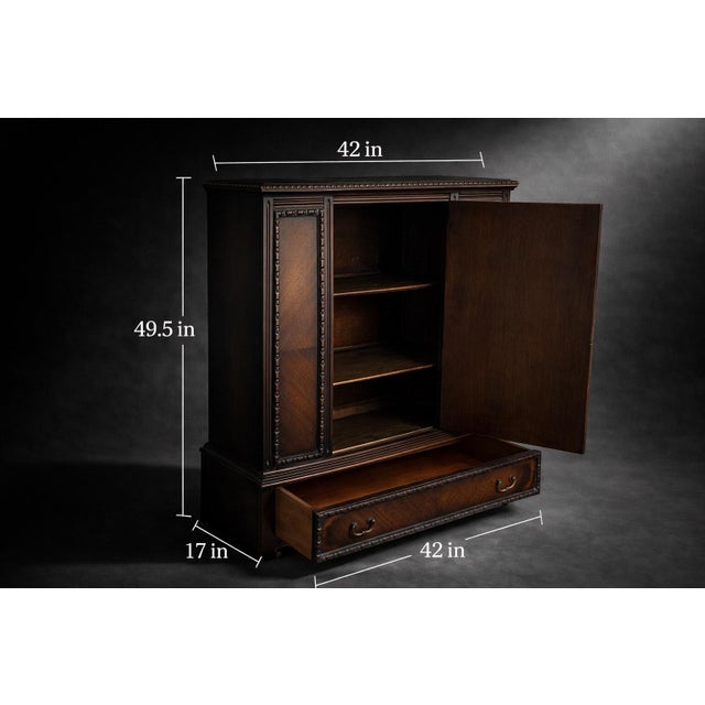 An elegant pair of vintage Baker Furniture mahogany cabinets featuring beautifully carved urn motifs and rich book-matched...