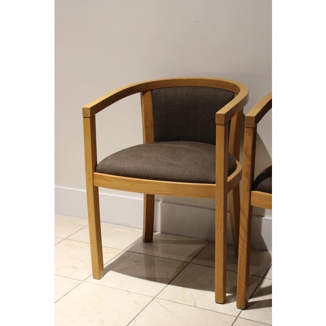 pair of vintage Scandinavian-inspired barrel back armchairs crafted from solid oak with elegantly curved wraparound arms...