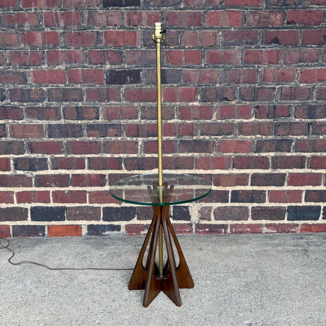 A striking mid-century modern floor lamp in the style of Mod Line, featuring a sculptural solid walnut base and integrated...