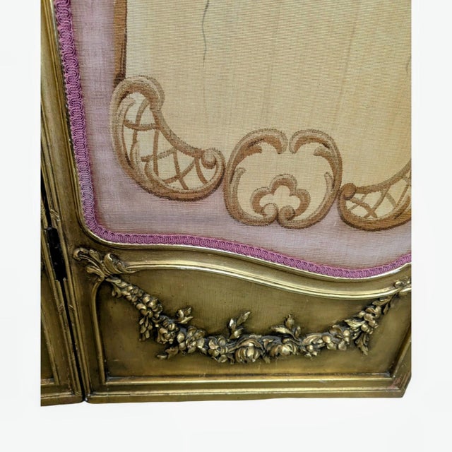 This Louis XV-style three-panel folding screen is characterized by its detailed ornamentation and elegant curves typical...
