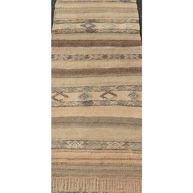 Measures: 2'5 x 7'3 This vintage Turkish kilim runner features an earthy and rustic design with a harmonious blend of...