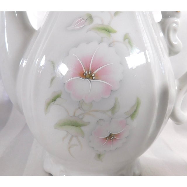 This is a smaller white shaped tea pot or coffee pot marked the Winrose Collection and Hand Decorated in USA. I don’t know...