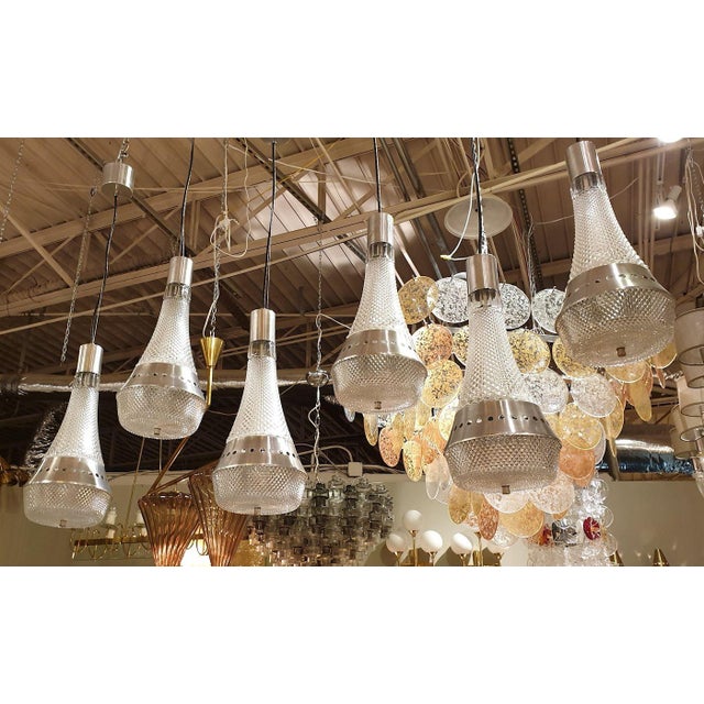 Set of two pairs of Italian, Mid-Century Modern, pendant chandeliers, circa 1970s. The four vintage pendant lights are...